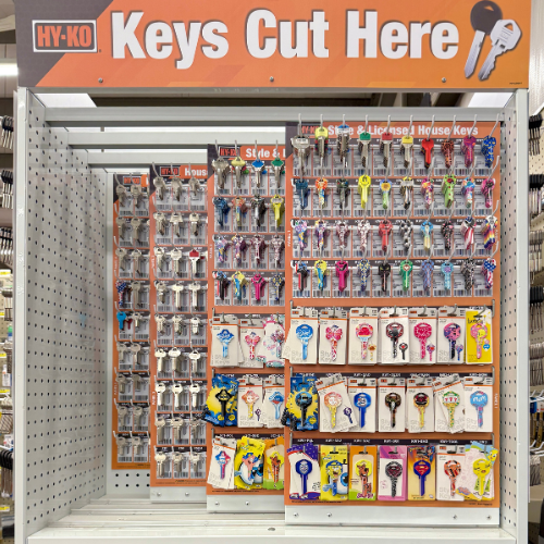 Display of keys cut here with various key designs in a store setting.